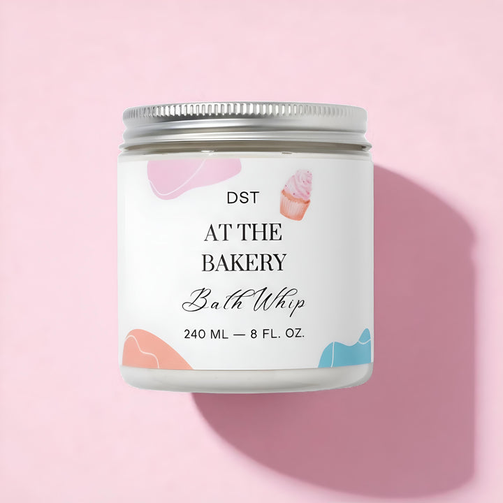 Bath whip container with a decorative label on a pink background