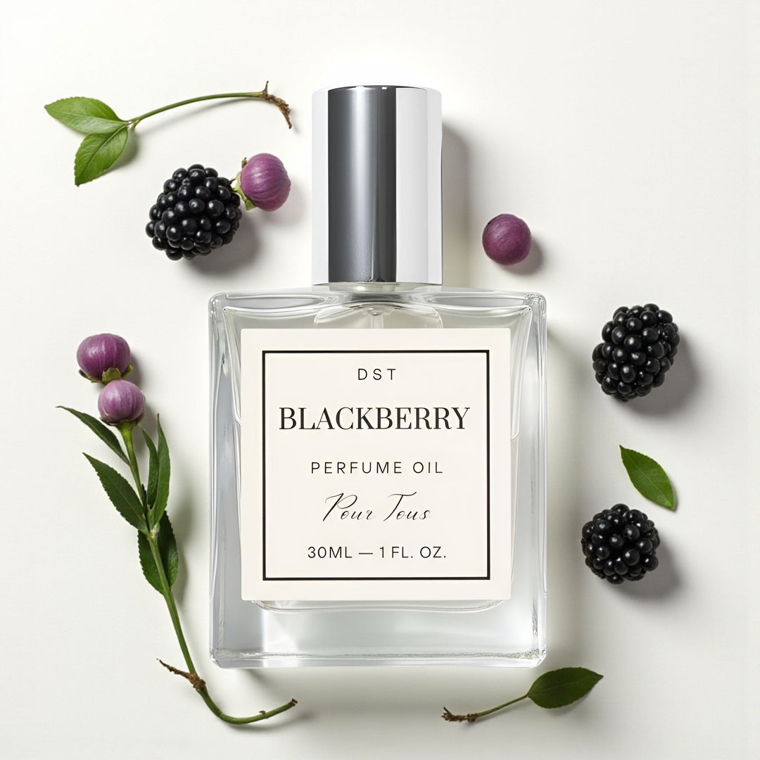 Perfume oil bottle labeled 'Blackberry' surrounded by blackberries on a light background
