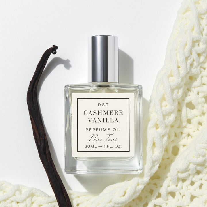 Cashmere Vanilla Perfume Oil on a ivory backdrop with vanilla bean and cashm