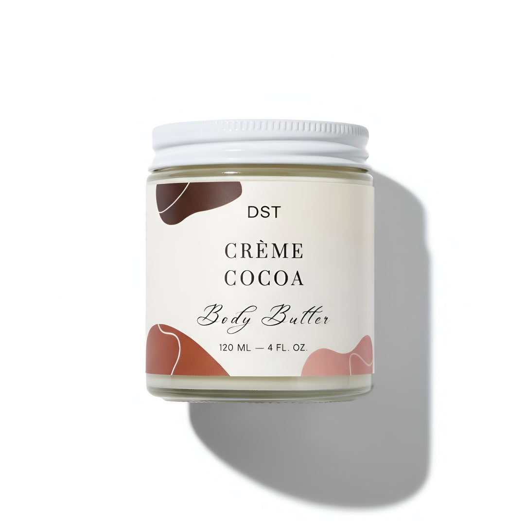 Jar of Crème Cocoa body butter with a white lid on a white background