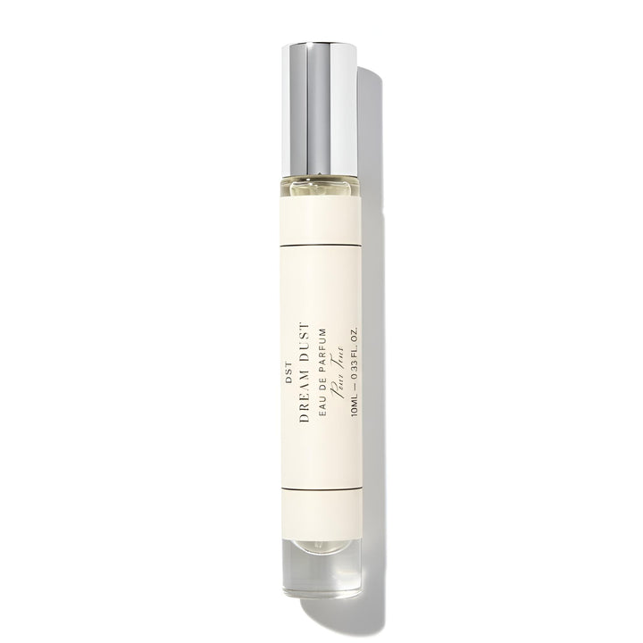 Perfume bottle labeled "Dream Dust' with silver cap on a white background