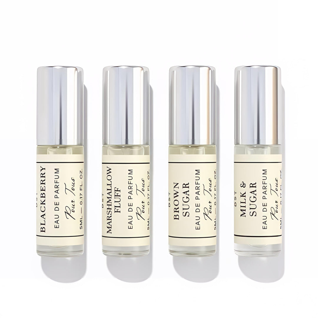 Four small DST Fragrances perfume bottles with labels on a white background