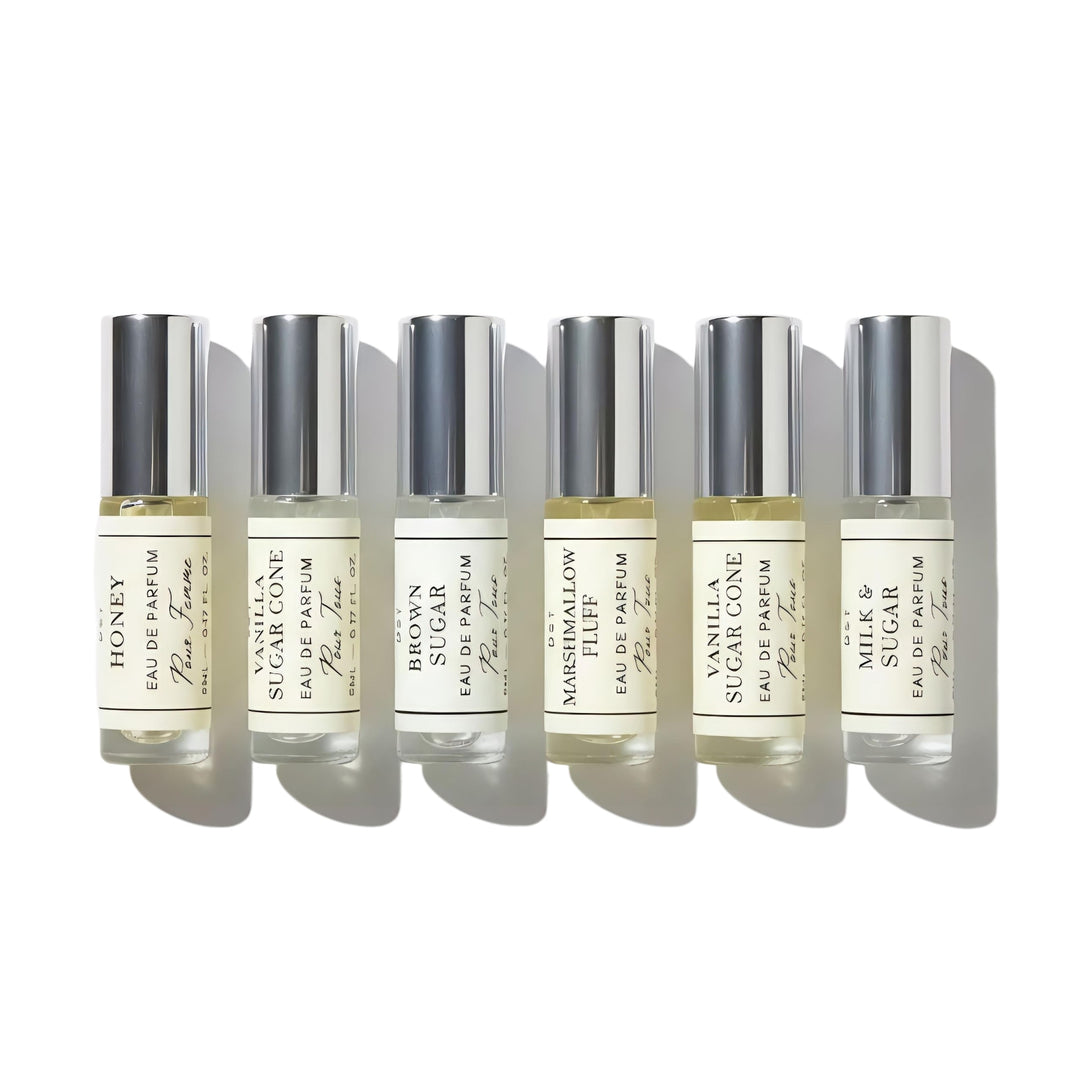 Set of six small DST Fragrances perfume bottles with labels on a white background