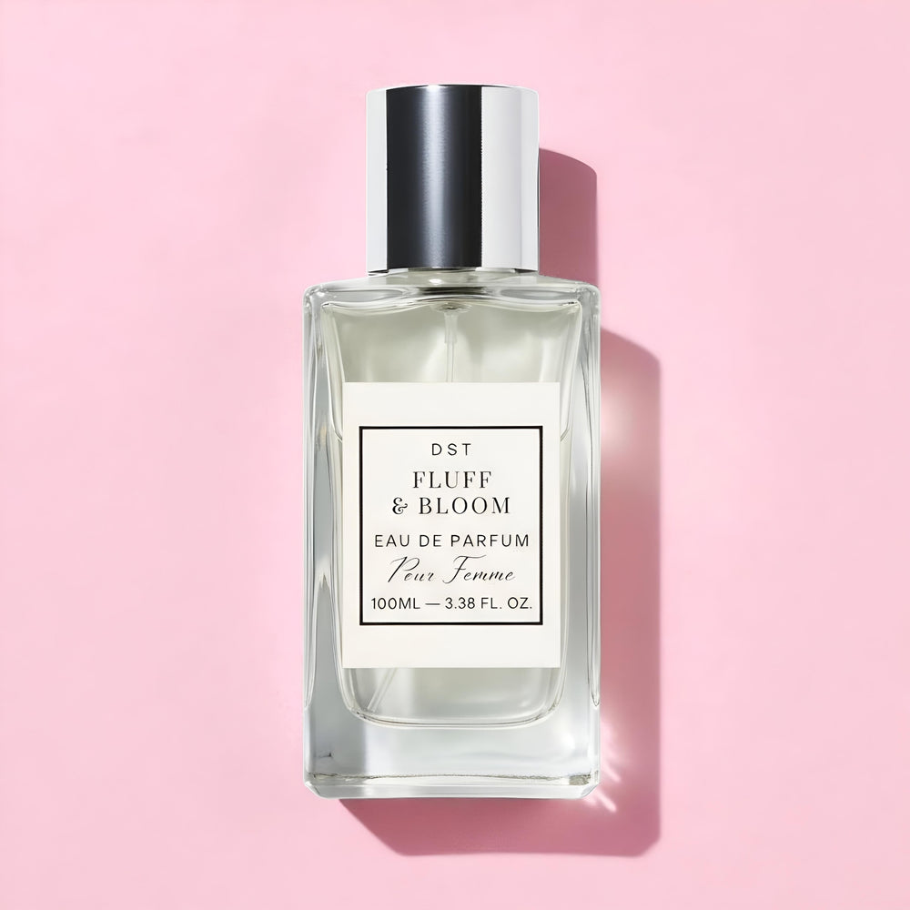 Perfume bottle labeled 'Fluff & Bloom' on a pink background