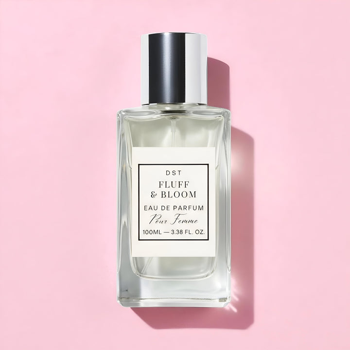 Perfume bottle labeled 'Fluff & Bloom' on a pink background