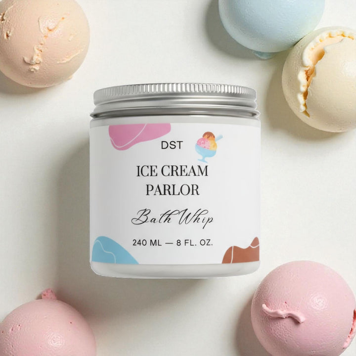 Bath whip container labeled 'Ice Cream Parlor' with bath bombs around on a light background