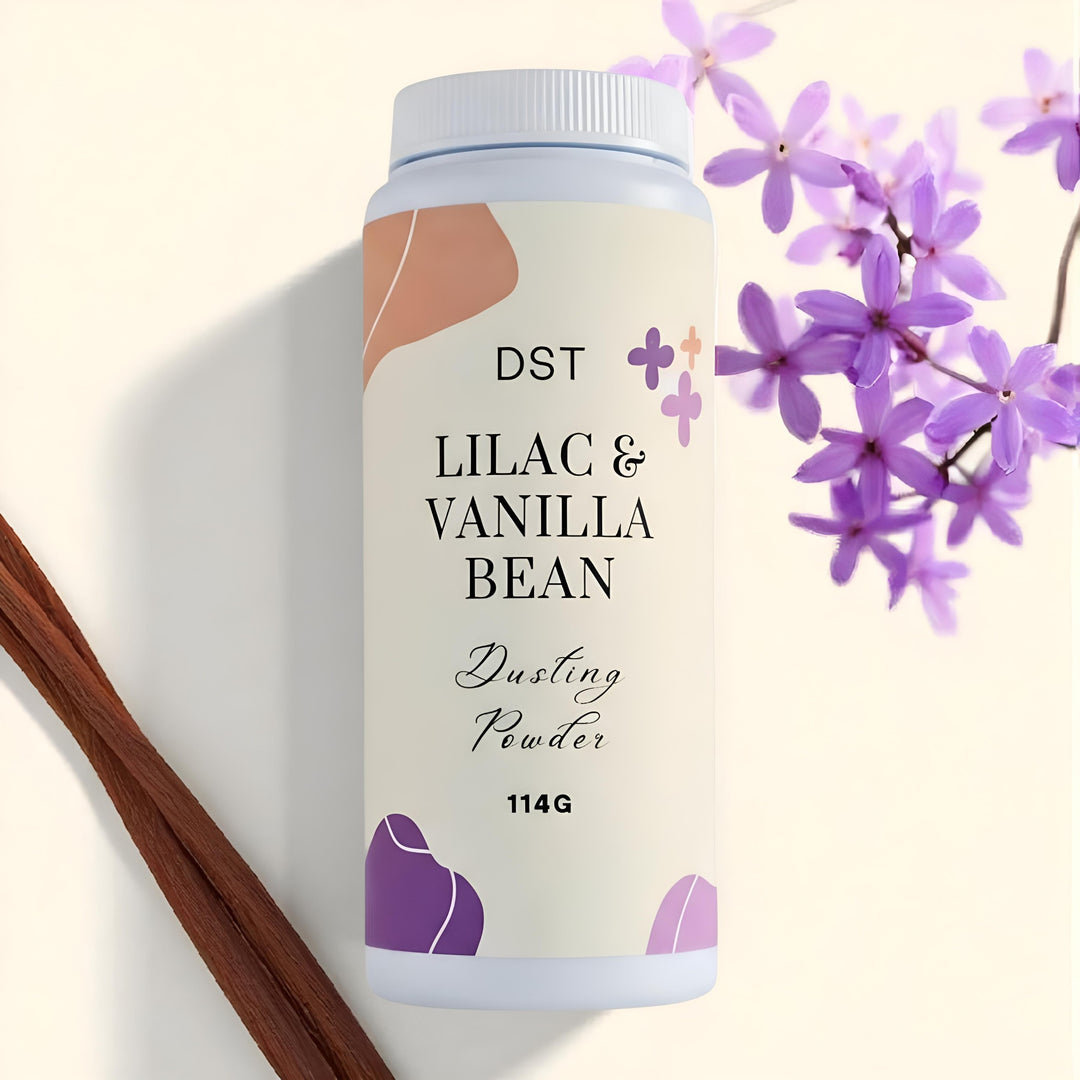 DST Lilac & Vanilla Bean dusting powder with flowers and vanilla beans on a light background