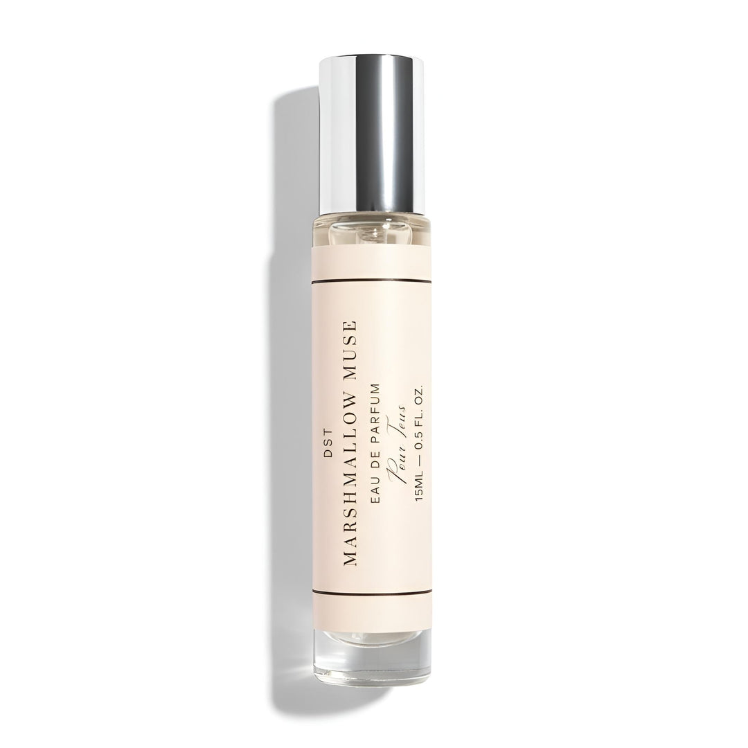 Small glass perfume bottle with a beige label on a white background