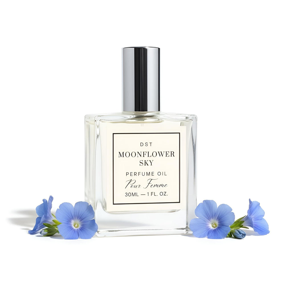 Perfume oil bottle labeled 'Moonflower Sky' surrounded by blue flowers on a white background