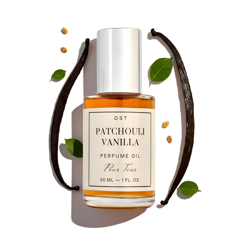 DST Fragrances Bottle of Patchouli Vanilla perfume oil with vanilla beans and leaves on a beige background