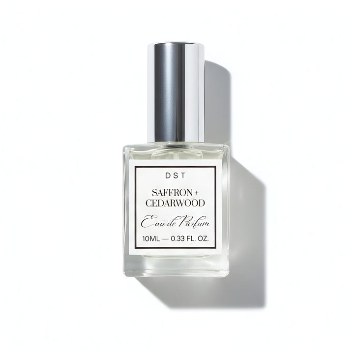 Perfume bottle labeled 'Saffron + Cedarwood' by DST on a white background