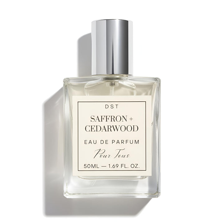 Perfume bottle labeled 'Saffron + Cedarwood' by DST on a white background