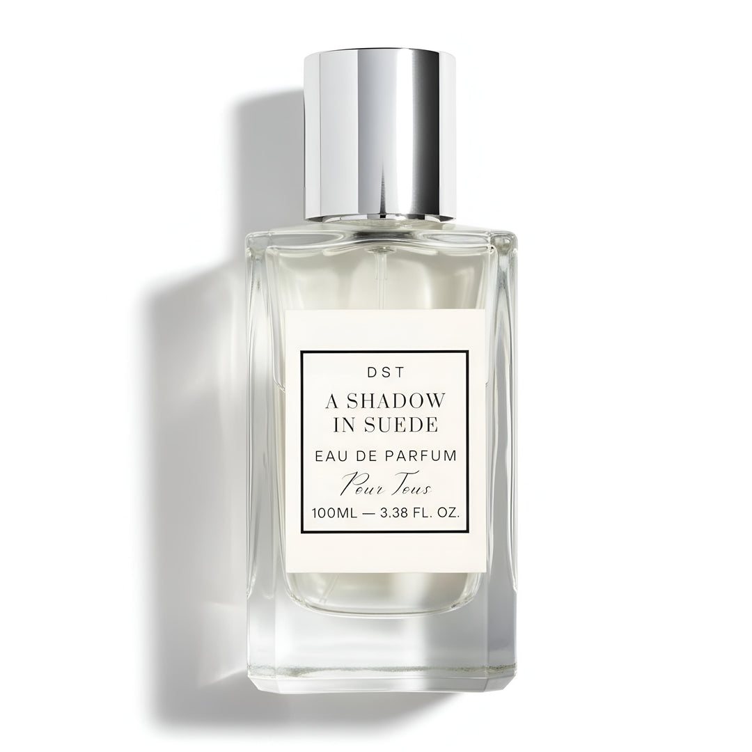 A 100ml bottle of DST's "A Shadow in Suede" Eau de Parfum against a white background.