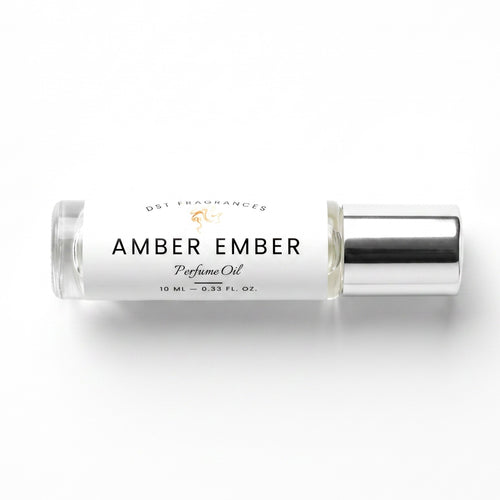 A 10 mL glass bottle of DST Fragrances Amber Ember Perfume Oil with a white label and a reflective silver cap, set against a clean white background.