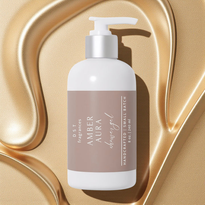 240ml bottle of Amber Aura scented Shower Gel by DST Fragrances against a molten gold background.