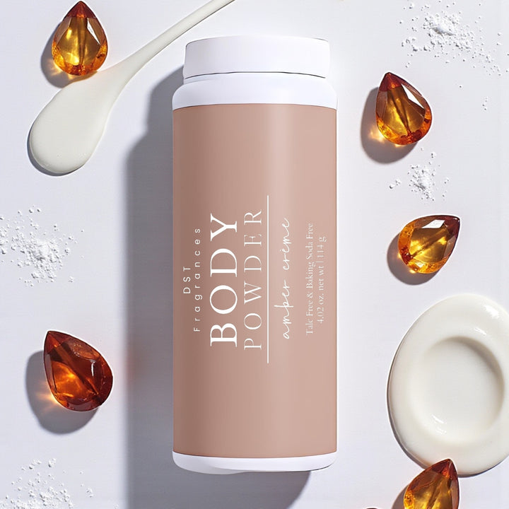 114g bottle of Amber Crème scented Body Powder by DST Fragrances against a white background with amber gemstones and spilled cream.