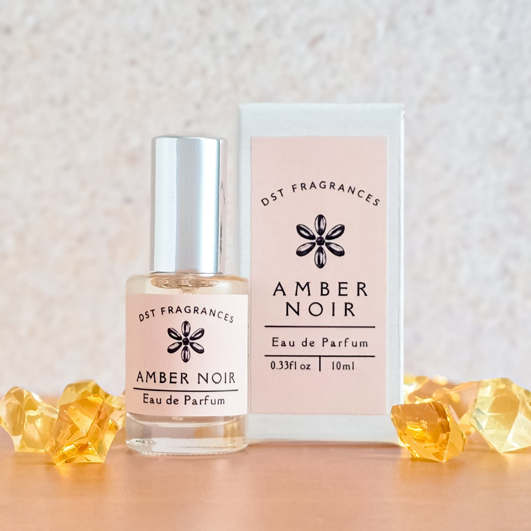 Amber Noir eau de parfum bottle and packaging on a neutral background