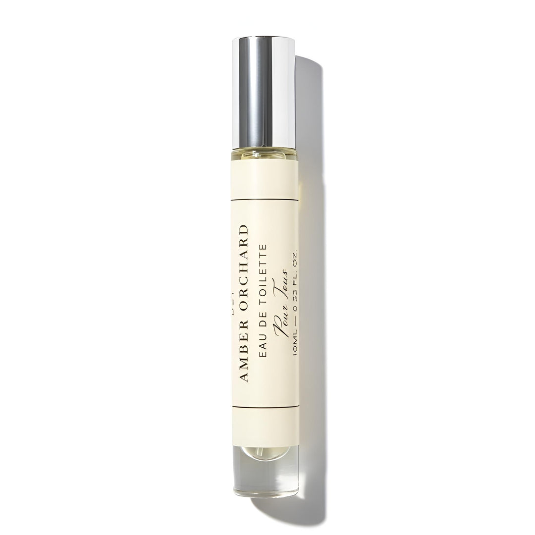 Roll-on perfume bottle labeled 'Amber Orchard Eau de Toilette' on a white background