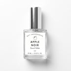 A 10 ml clear glass bottle of DST Fragrances Apple Noir Eau de Toilette with a reflective silver cap and a white label, set against a plain white background with a soft shadow.