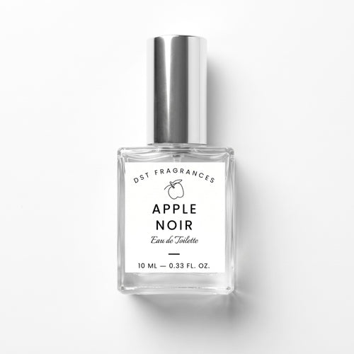A 10 ml clear glass bottle of DST Fragrances Apple Noir Eau de Toilette with a reflective silver cap and a white label, set against a plain white background with a soft shadow.