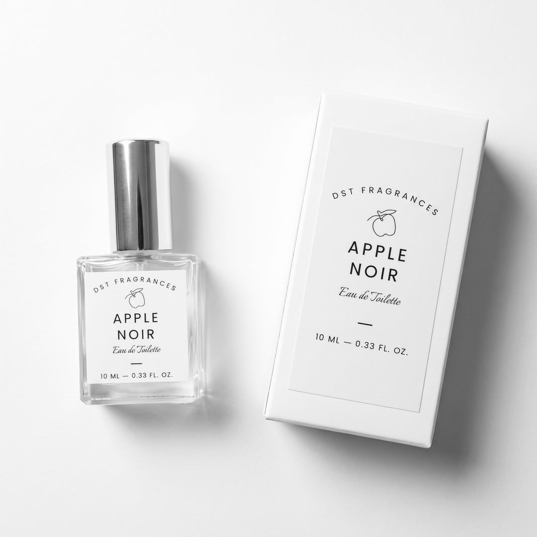 A clear glass perfume bottle with a silver cap next to its white rectangular box, both labeled &