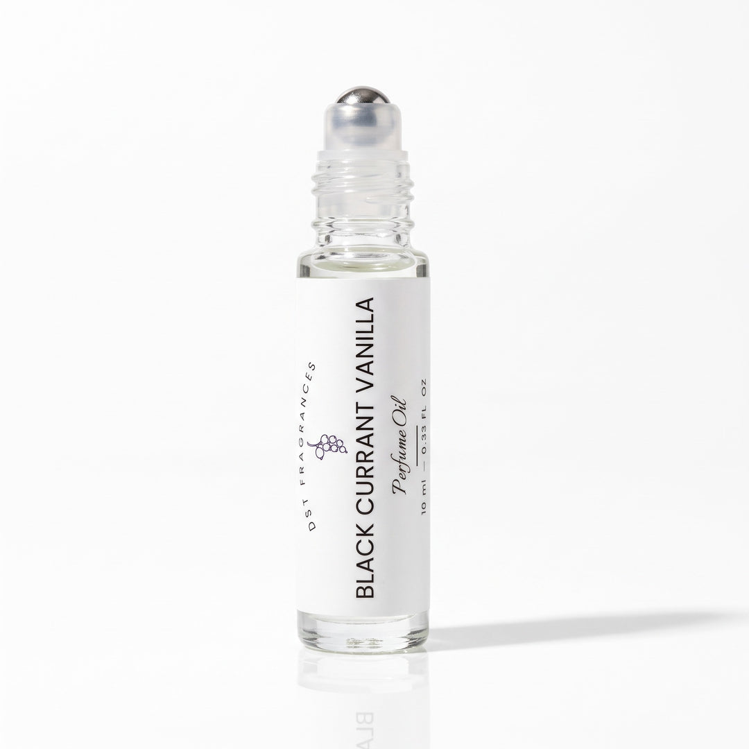 10ml bottle of Black Currant Vanilla scented perfume Oil  with the cap removed to expose rollerball dispenser mechanis by DST fragrances against a white background.