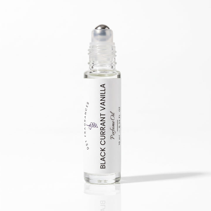 10ml bottle of Black Currant Vanilla scented perfume Oil  with the cap removed to expose rollerball dispenser mechanis by DST fragrances against a white background.