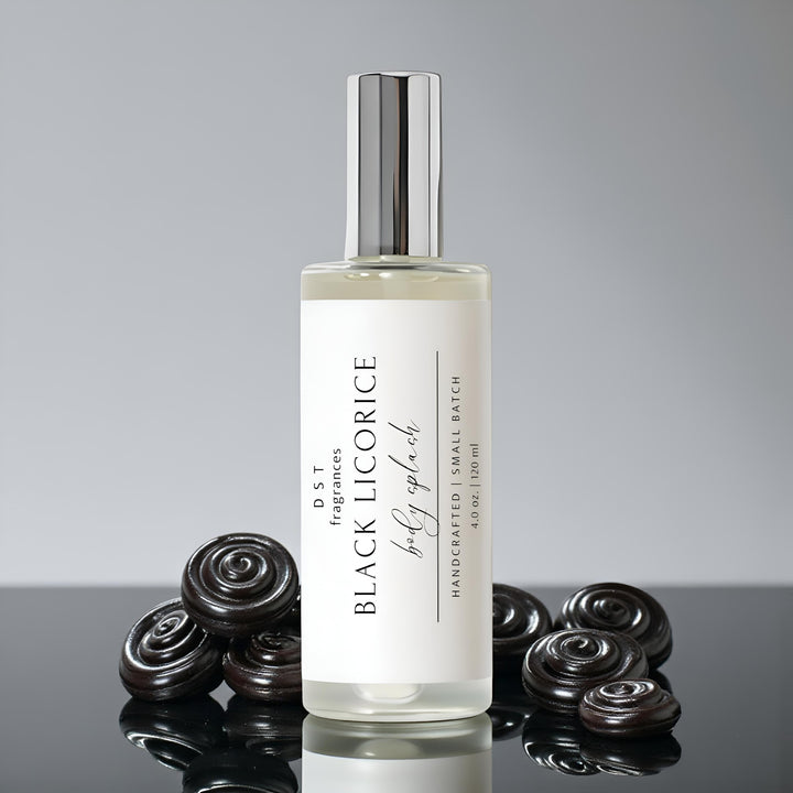 4oz bottle of Black Licorice Body Splash by DST Fragrances sitting on a shiny black surface with black licorice candies against a grey background.