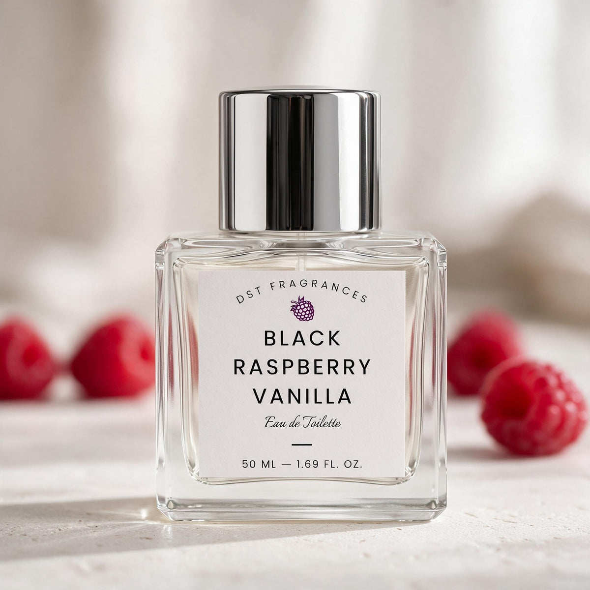 A 50 ml bottle of DST Fragrances Black Raspberry Vanilla Eau de Toilette, featuring a clear glass bottle, white label, and a shiny silver cap, set against a soft-focus background with fresh raspberries.