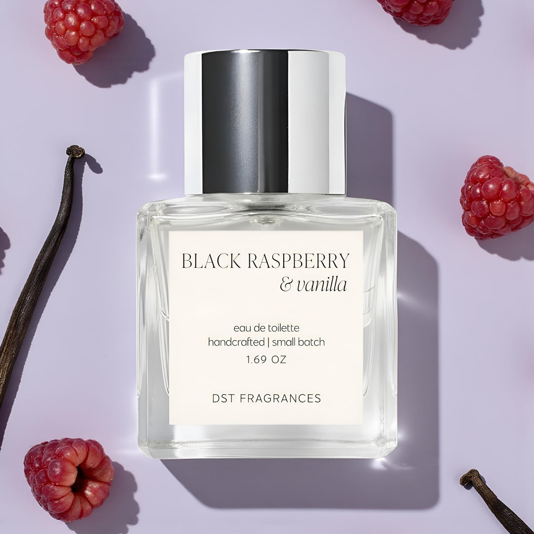 50ml bottle of 'Black Raspberry & Vanilla' Eau de toilette by DST Fragrances on a light purple background with raspberries and vanilla beans.