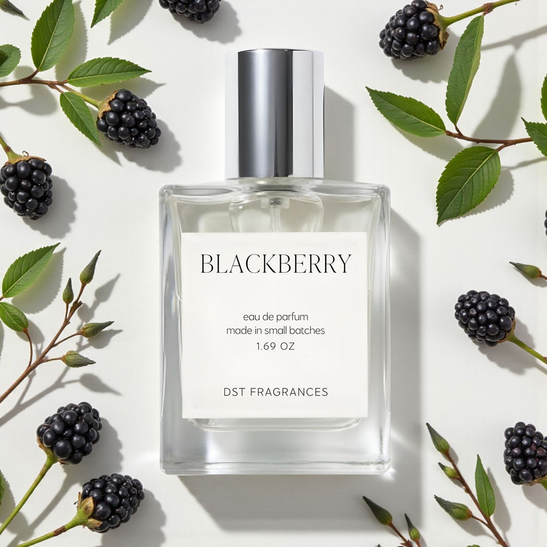 Perfume bottle labeled 'Blackberry' by DST Fragrances surrounded by blackberries and leaves on a light background