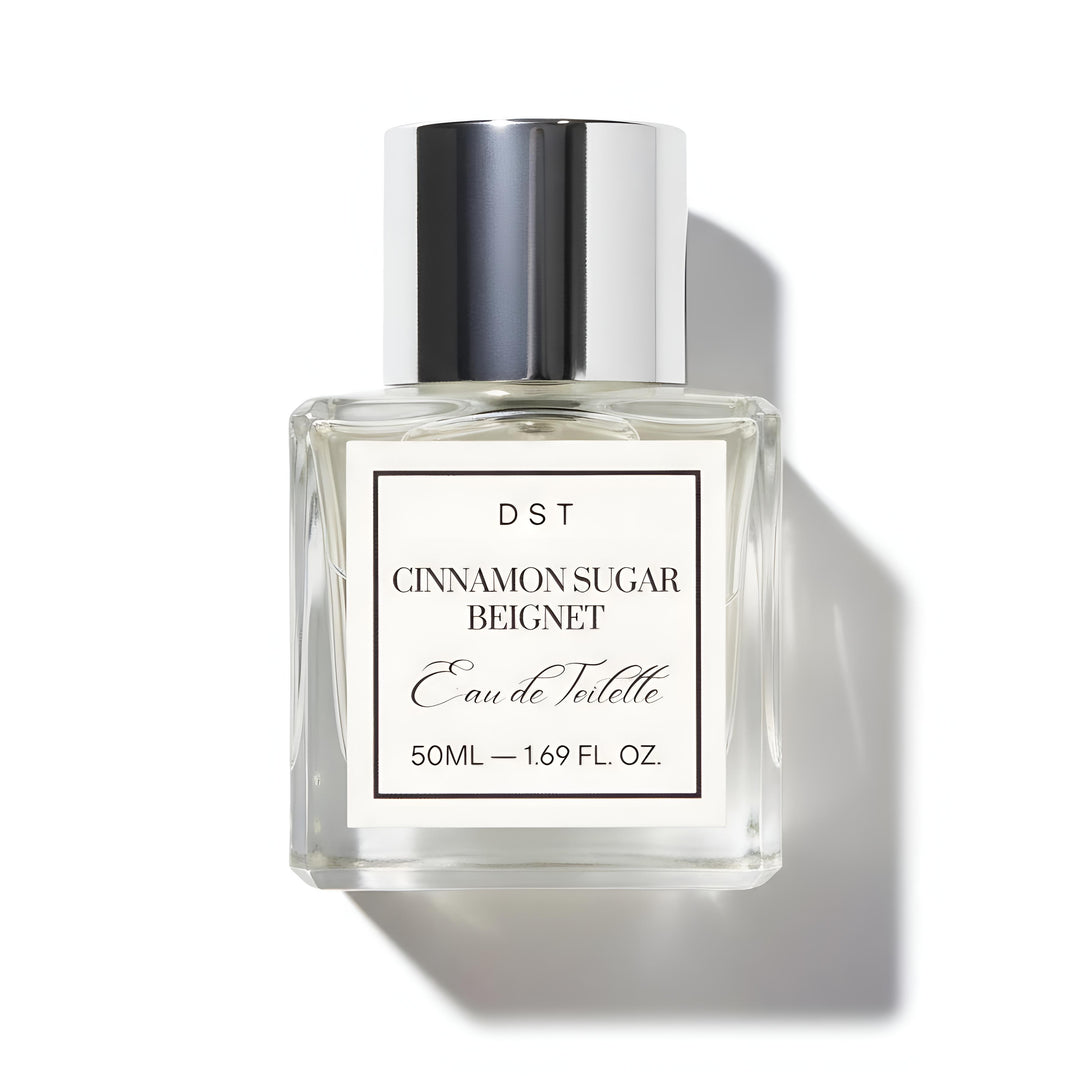 Perfume bottle labeled 'Cinnamon Sugar Beignet' by DST on a white background