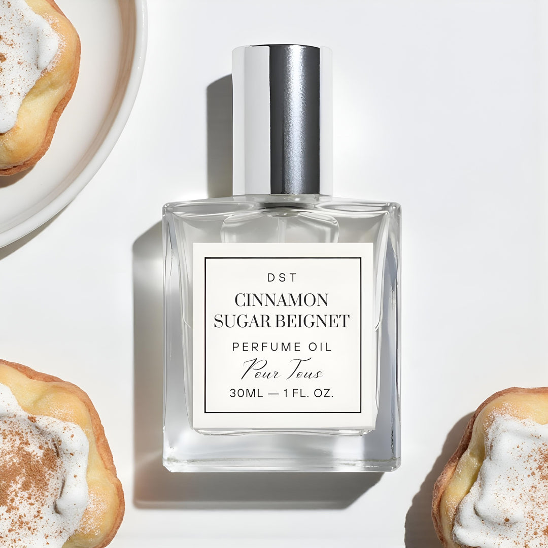 Perfume oil bottle labeled 'Cinnamon Sugar Beignet' with pastries in the background