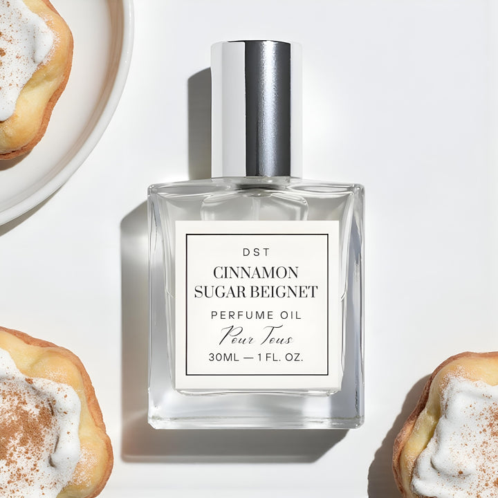 Perfume oil bottle labeled 'Cinnamon Sugar Beignet' with pastries in the background