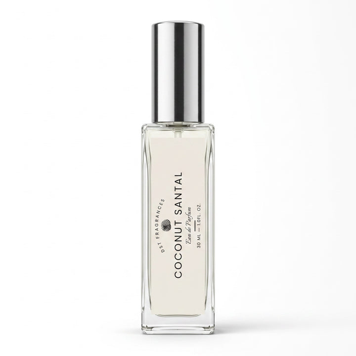A clear glass roll-on perfume bottle with a reflective silver cap, containing a very pale warm cream liquid. The bottle features a white label with black text reading &