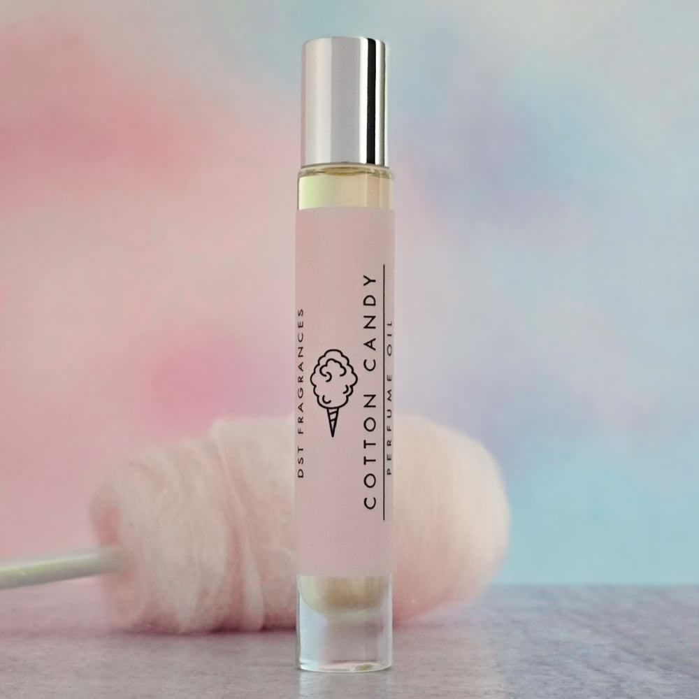 Roll-on perfume bottle labeled 'Cotton Candy' with a fluffy pink object in the background