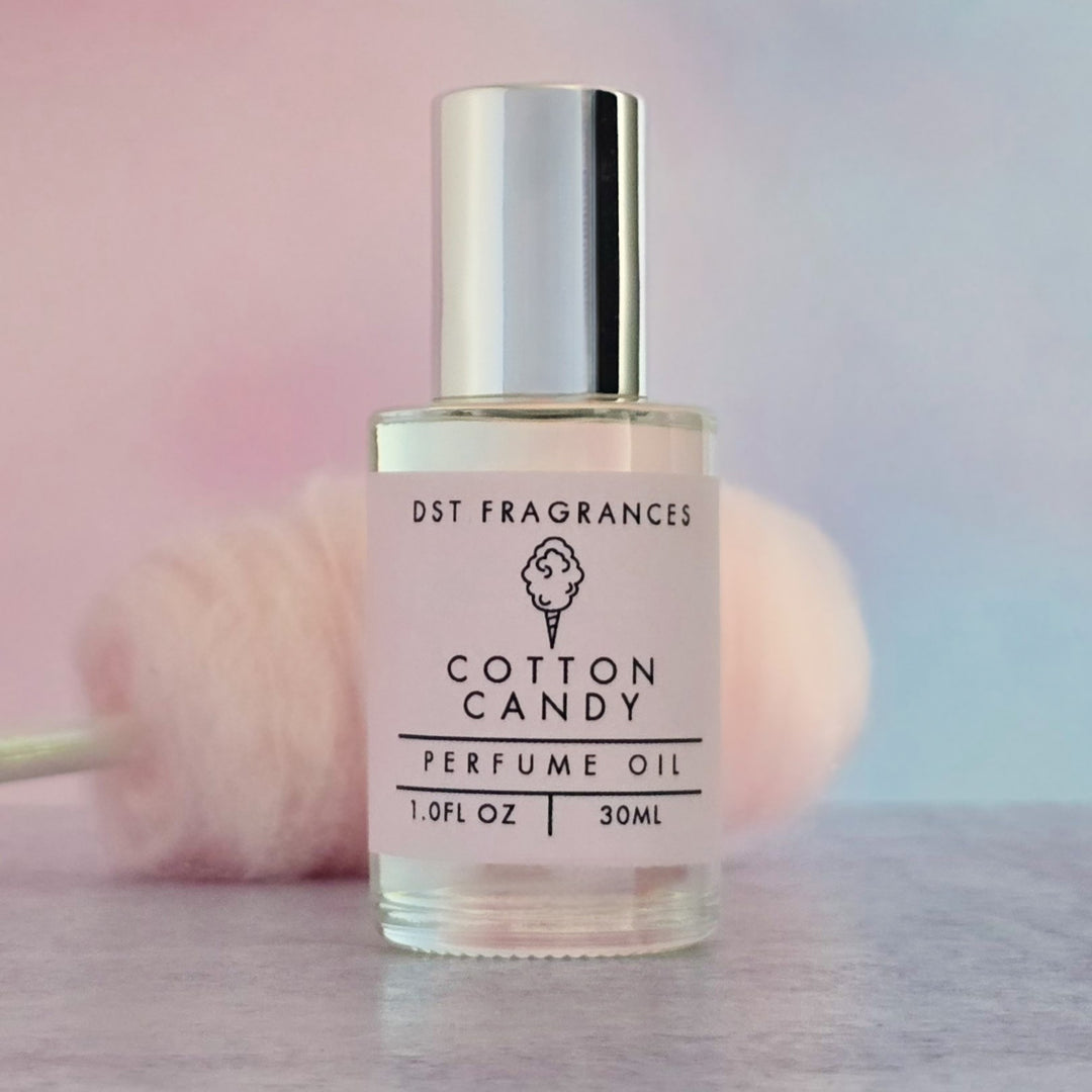 Bottle of Cotton Candy perfume oil with a cotton candy in the background