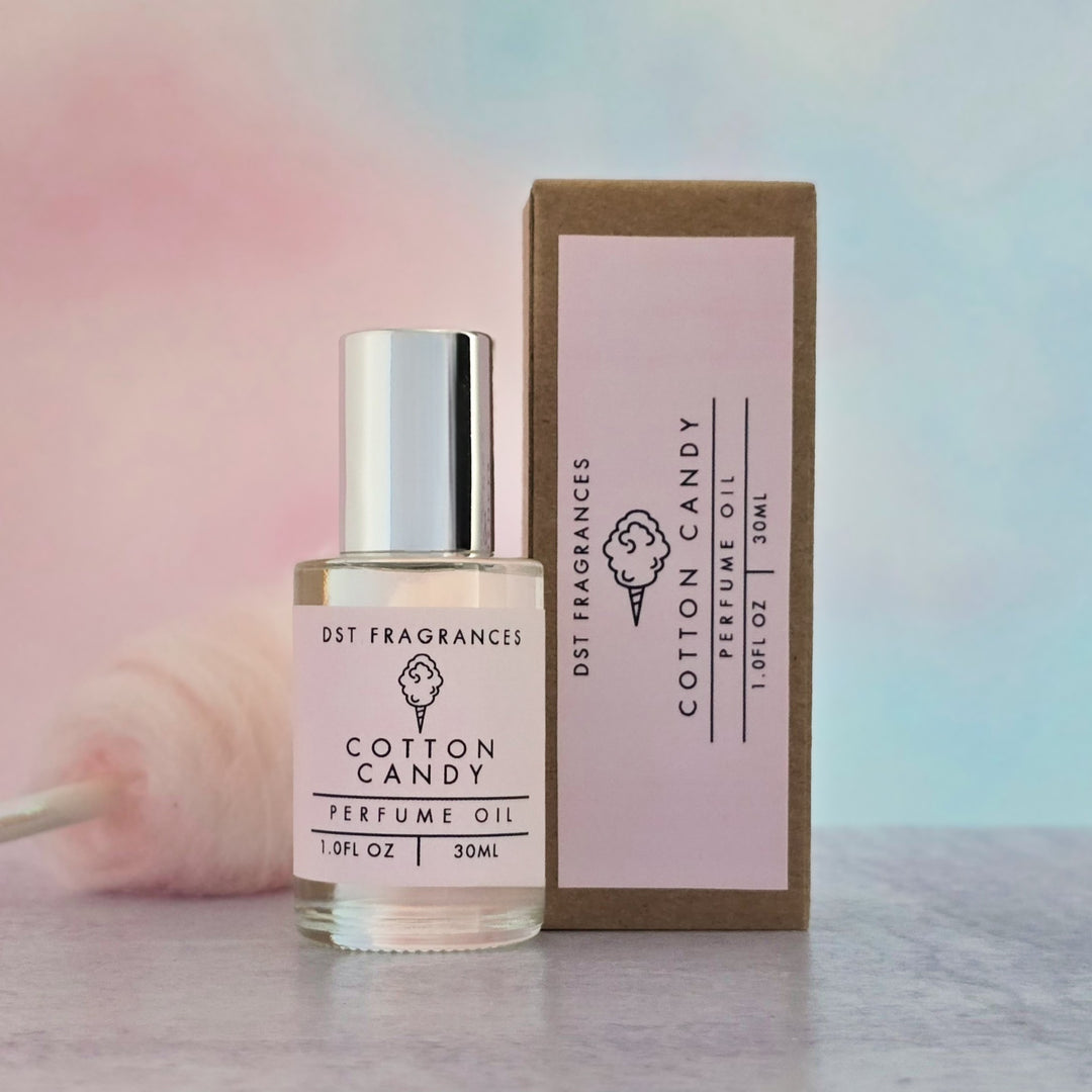Cotton candy perfume oil bottle and packaging on a blurred background