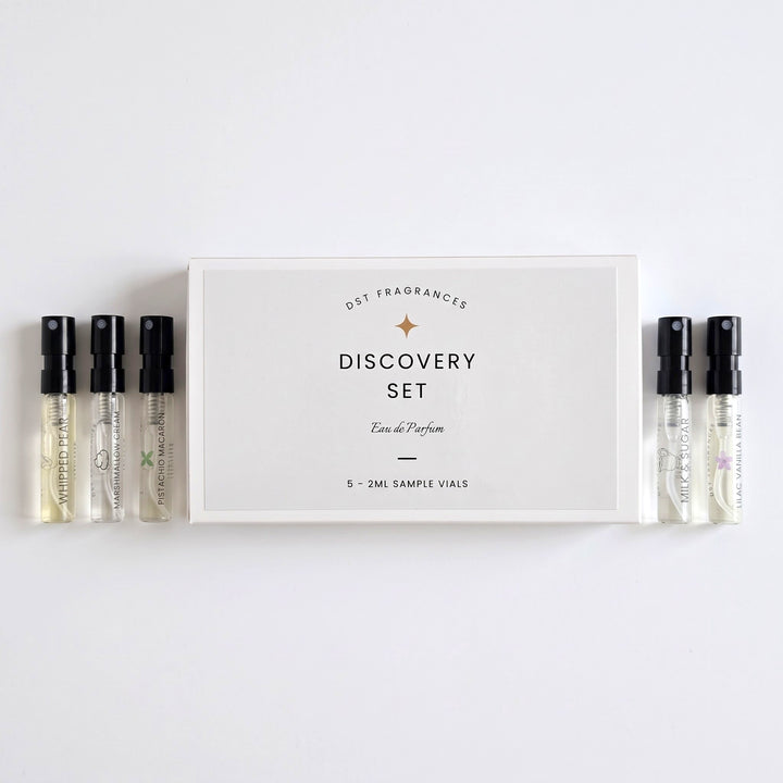 5 2ml Sample Vials of Eau de Parfum by DST Fragrances laying next to its box on a white background.