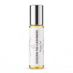 A 10 mL glass rollerball bottle of DST Fragrances Golden Fig Cashmere perfume oil, featuring a white label and a reflective silver cap, set against a plain white background.