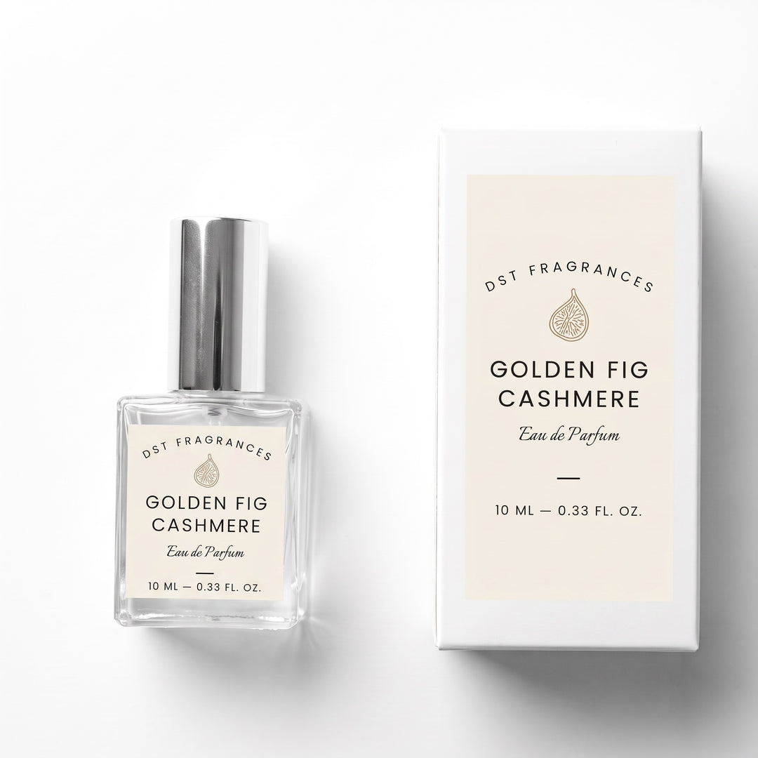 A clear glass perfume bottle with a silver cap stands beside its white box. Both the bottle label and the box read &