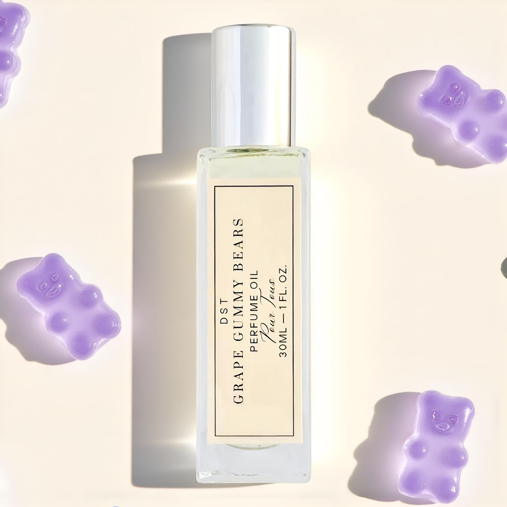 Perfume oil bottle with grape gummy bear flavor surrounded by purple gummy bear candies on a light background