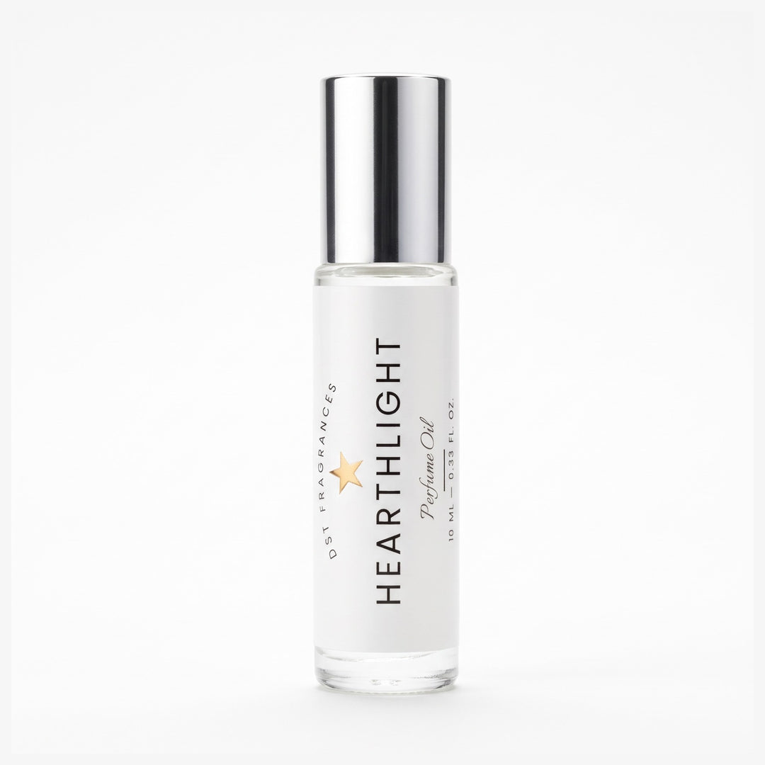 A clear glass roll-on bottle of Heartlight Perfume Oil with a reflective silver cap, set against a seamless white background.