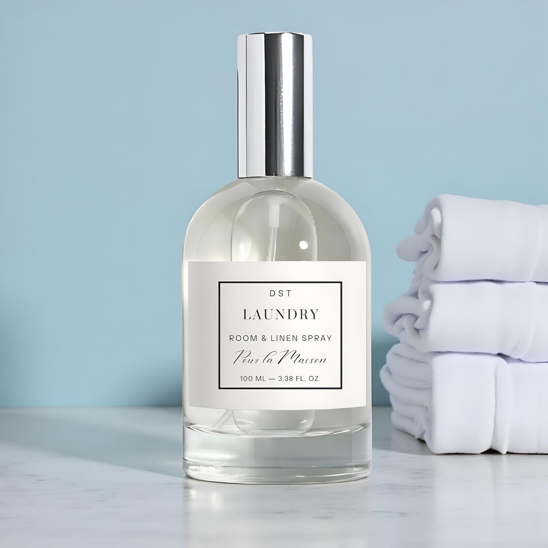 Laundry room and linen spray bottle with folded white towels on a light blue background