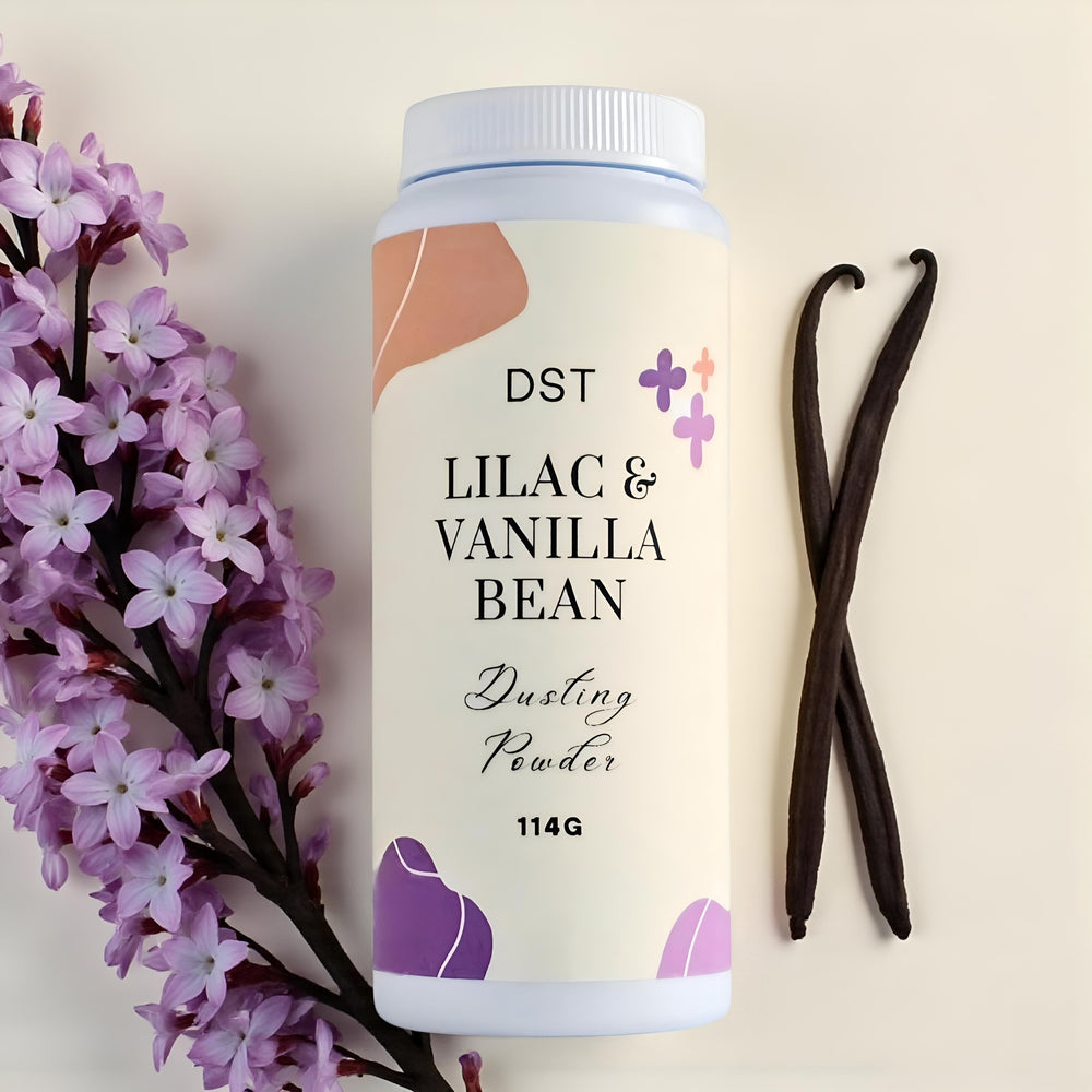 DST Lilac & Vanilla Bean dusting powder with flowers and vanilla beans on a light background