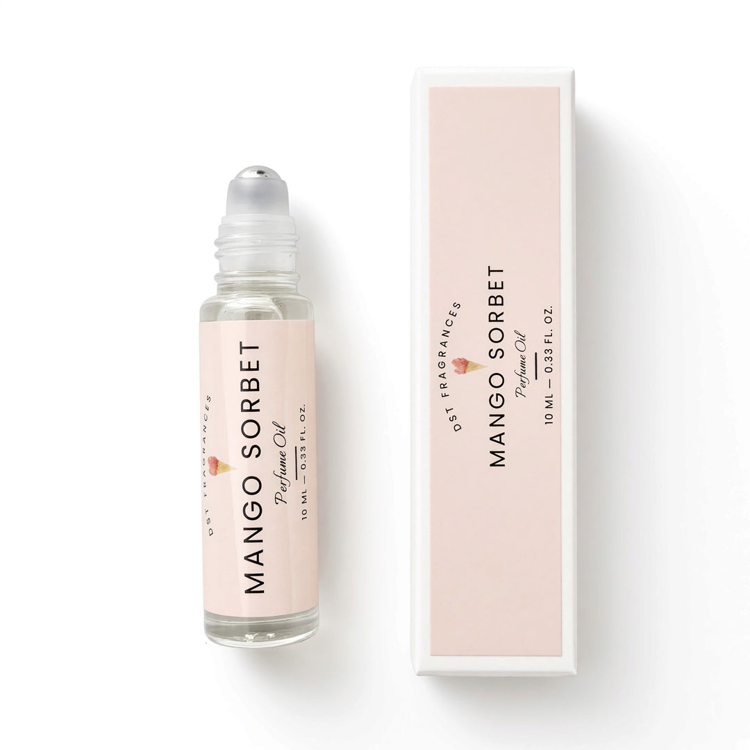 A bottle of Mango Sorbet perfume oil with a clear cap and a pale pink label, shown next to its matching rectangular box on a clean white background.