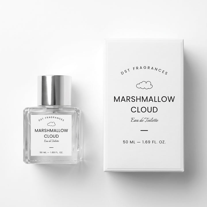 A clear glass perfume bottle with a silver cap next to its white packaging box, both labeled &