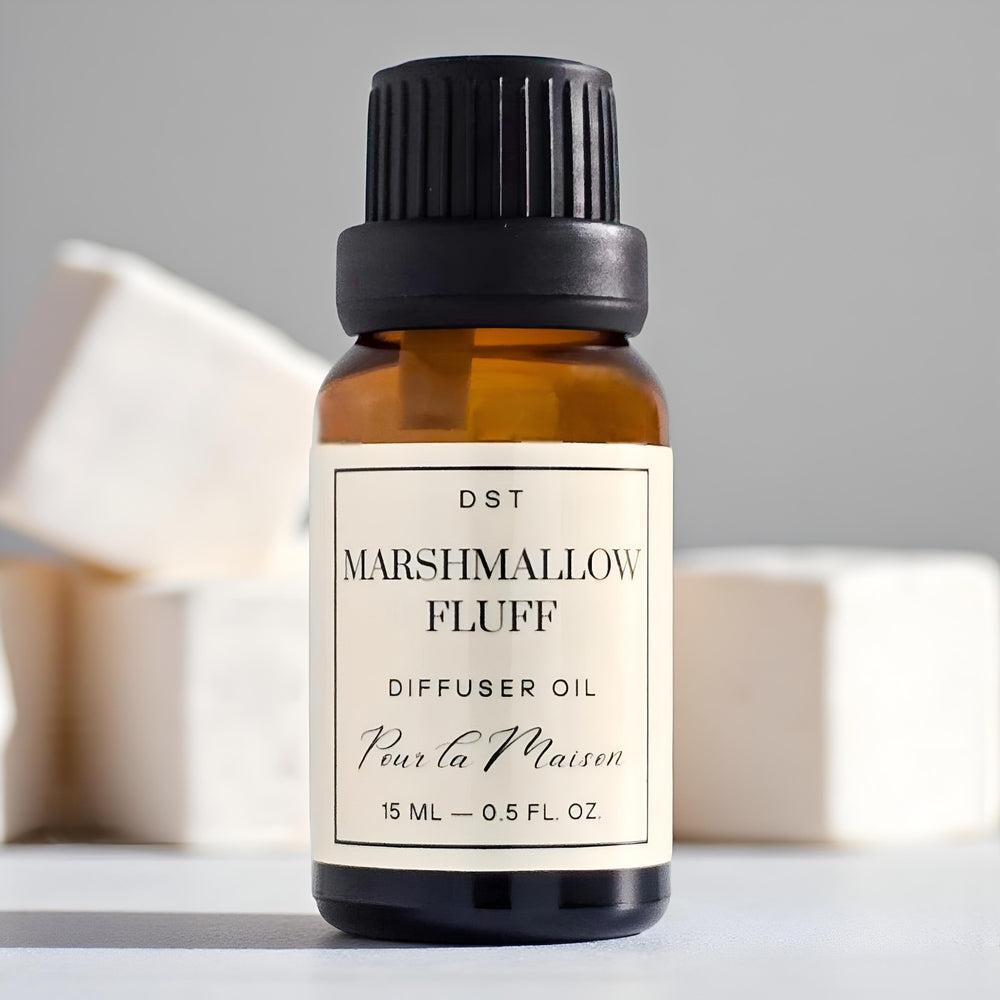 Diffuser oil bottle labeled 'Marshmallow Fluff' with packaging on a light blue background