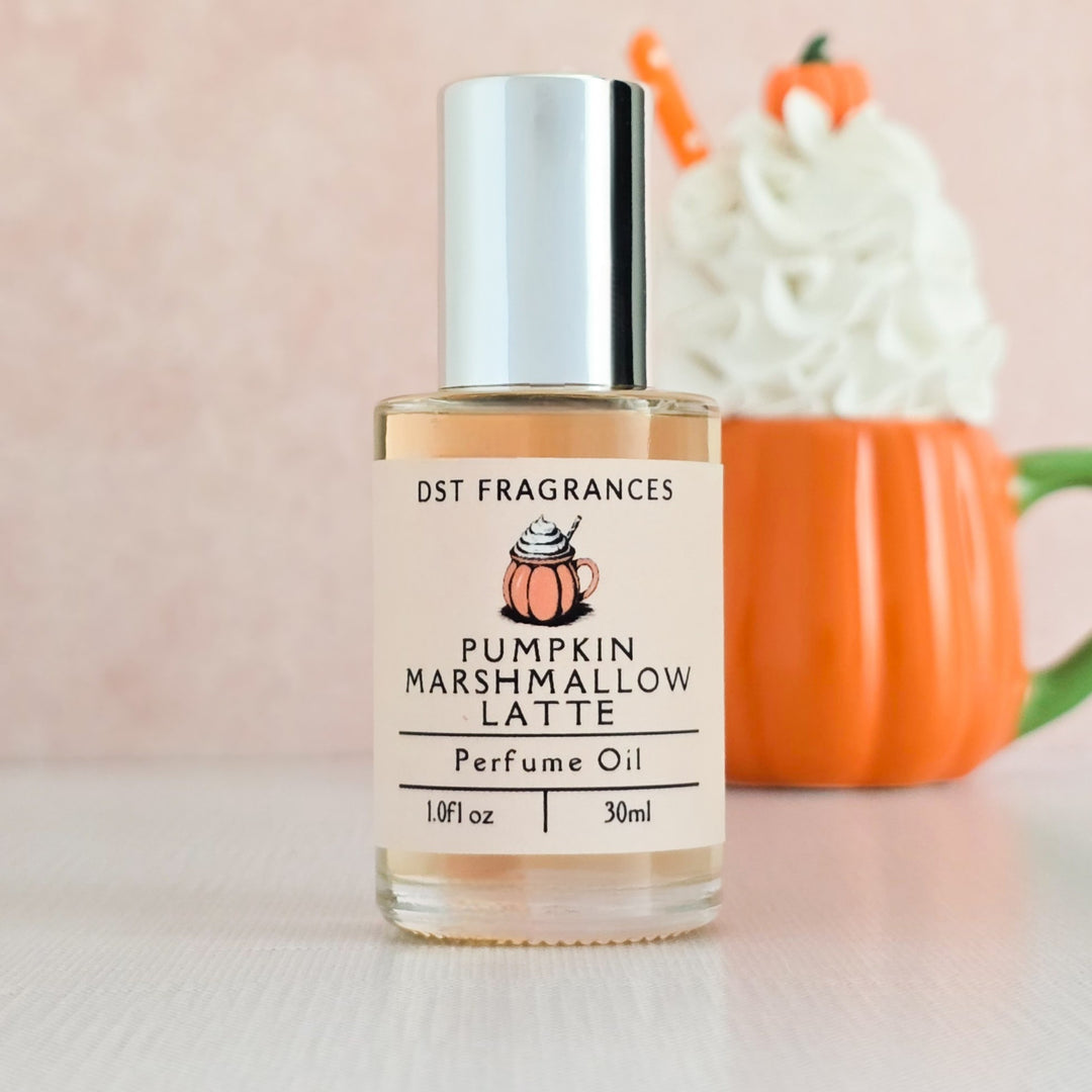 Bottle of Pumpkin Marshmallow Latte perfume oil with a pumpkin-themed mug in the background.