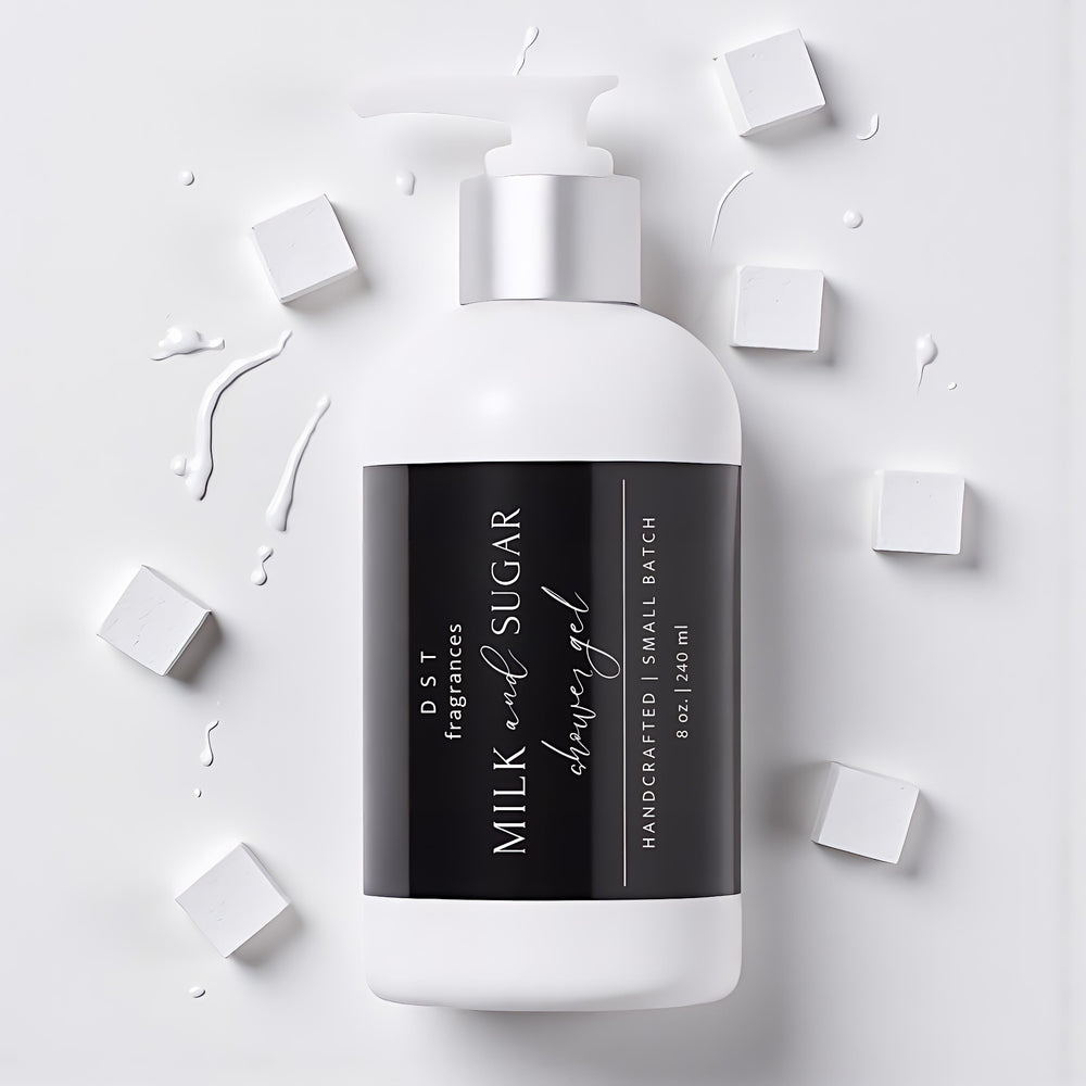 240ml bottle of Milk and Sugar Scented Shower Gel by DST Fragrances laying on a light grey surface with splashes of white milk and white sugar cubes surrounding the bottle.